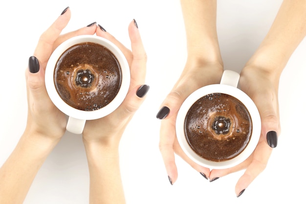 Mains féminines avec une tasse de thé blanc vue de dessus main féminine avec une tasse de café noir sur le dessus de table blanc