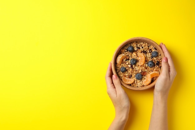 Mains féminines tenant un bol avec du granola