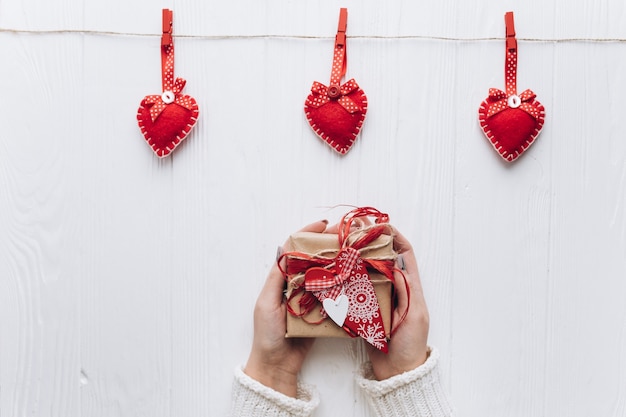 Mains féminines tenant le cadeau pour la Saint-Valentin.