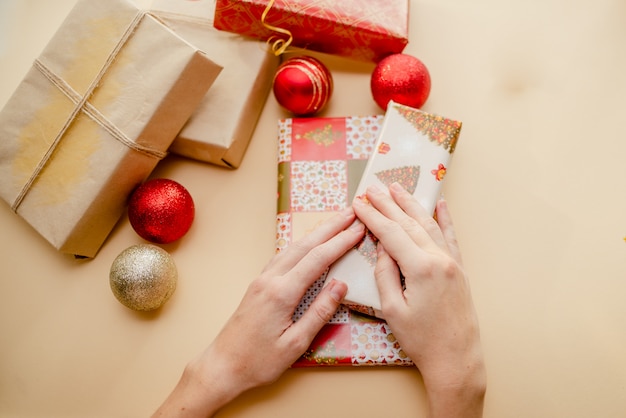 Mains féminines tenant des cadeaux et emballer des cadeaux