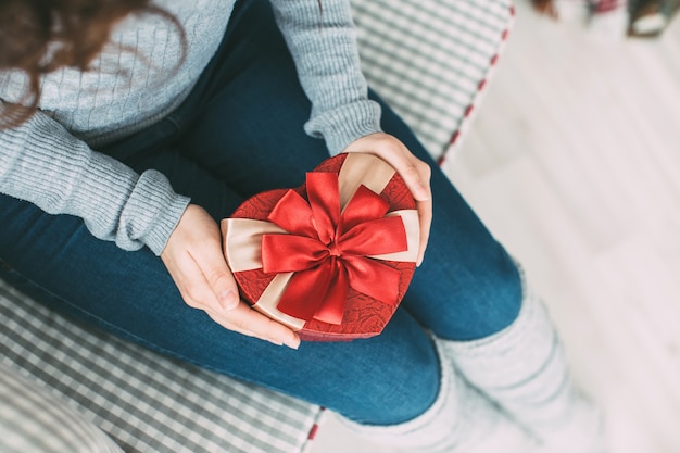 Mains féminines tenant coeur de boîte-cadeau