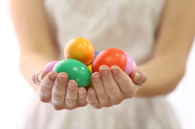 Mains féminines tenant des oeufs de Pâques isolés sur blanc