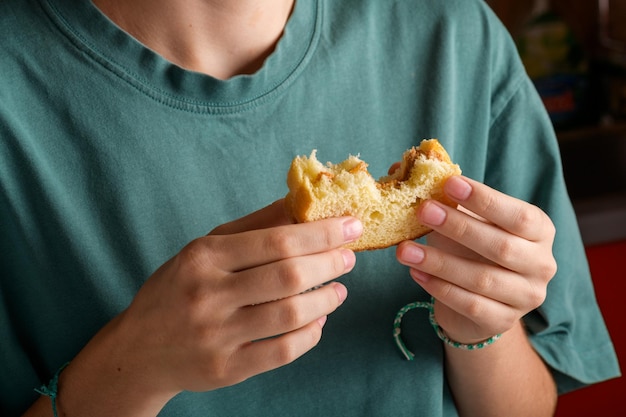 Des mains féminines tenant un sandwich au beurre d'arachide mordu avec du miel de pain de blé