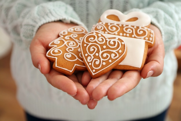 Mains féminines tenant de savoureux biscuits en pain d'épice