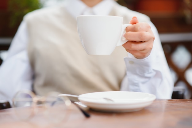 Mains féminines tenant une tasse de café