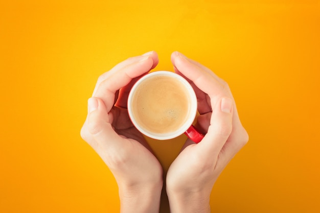 Mains féminines tenant une tasse de café