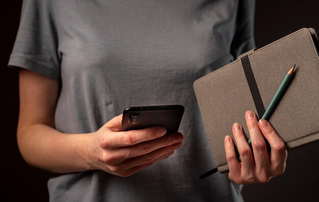 Mains féminines tenant le téléphone et prenant des rendez-vous, tenant le planificateur. Étudiant utilisant un smartphone et un ordinateur portable la nuit