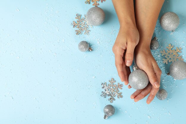 Des mains féminines tiennent des boules sur fond bleu