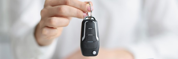 Les mains féminines tiennent une clé électronique d'une nouvelle voiture