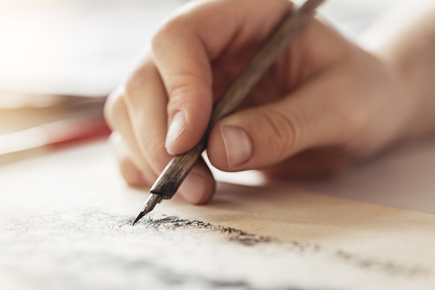 Les mains féminines tiennent le stylo-plume pour le dessin, les exercices créatifs.