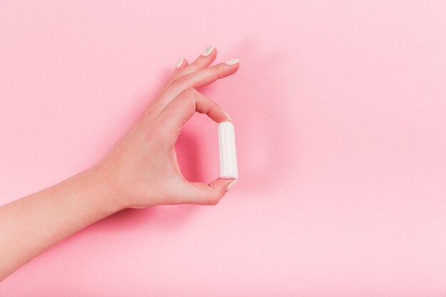 Les mains féminines tiennent le tampon sur une rose.