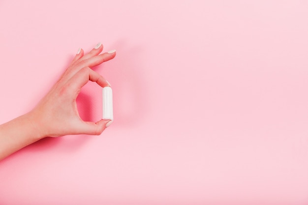 Les mains féminines tiennent le tampon sur une rose.