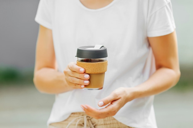 Les mains féminines tiennent une tasse à café réutilisable. Mode de vie durable. Concept écologique.