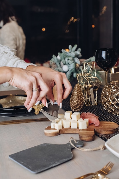 Mains féminines trancher un morceau de fromage à la table de fête