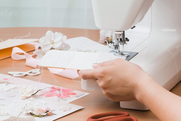 Mains Féminines Travaillant Pour La Machine à Coudre Blanche Scrapbooking Pour Mariage Ou Autres Décorations Festives