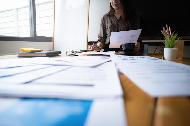 Mains de femme d'affaires ou de comptable sur la paperasse avec calculatrice