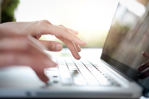 Les mains de la femme d&#39;affaires tapant sur le clavier de l&#39;ordinateur portable