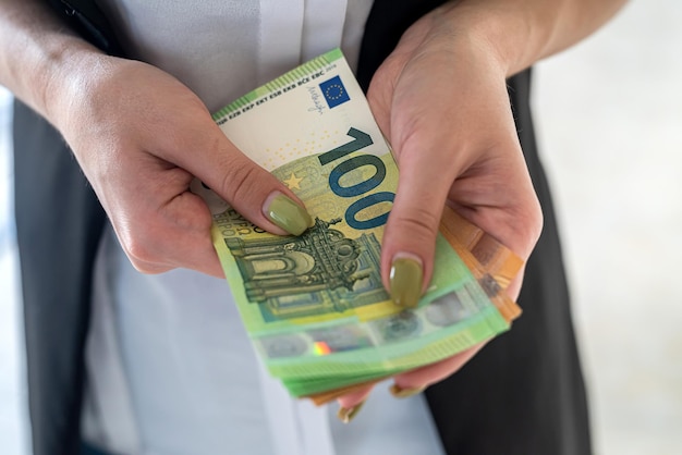 Les mains d'une femme d'affaires tiennent des billets en euros. concept financier