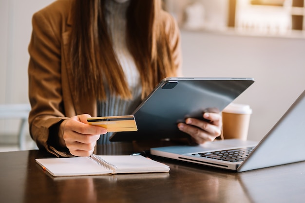 Mains de femme d'affaires utilisant un smartphone et tenant une carte de crédit avec un diagramme d'effet de couche numérique comme concept d'achat en ligne