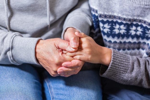 Mains d'une femme âgée et d'une garde d'enfants et d'un soutien