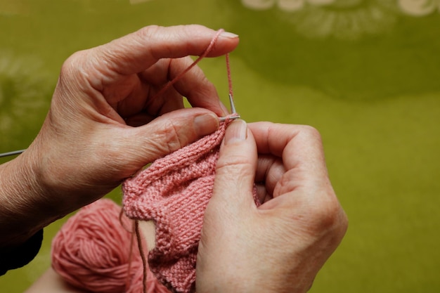 des mains d'une femme âgée tricotant