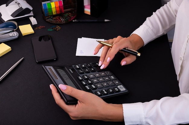 Les mains de la femme à l'aide d'une calculatrice