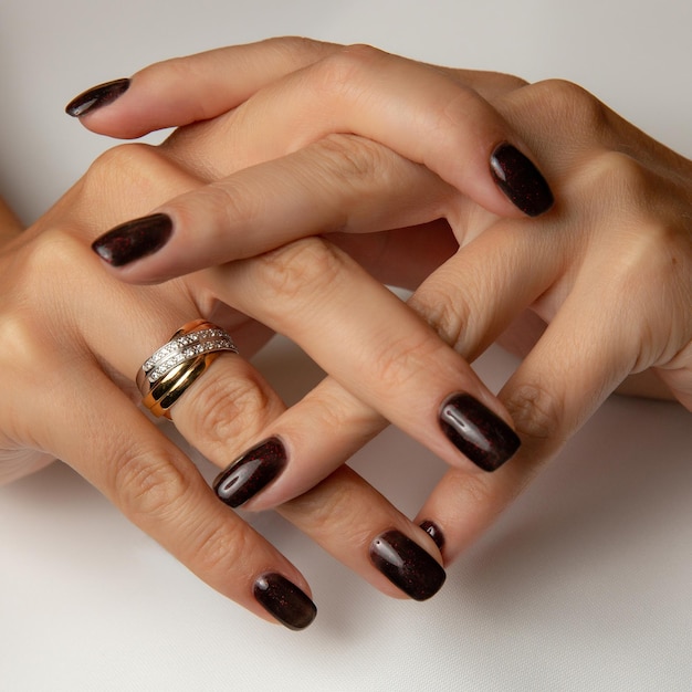 Les mains d'une femme avec un anneau sur la main gauche et un anneau sur la main droite.