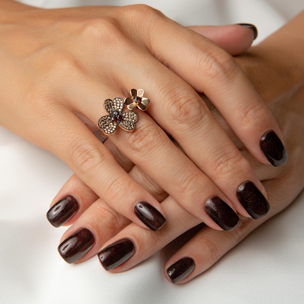 Les mains d'une femme avec un anneau sur la main gauche et un anneau avec un papillon dessus.