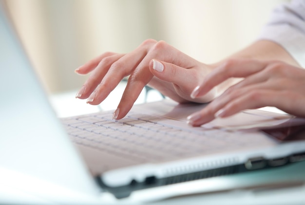 Mains de femme appuyant sur les touches d'un clavier d'ordinateur portable essayant d'accéder aux données