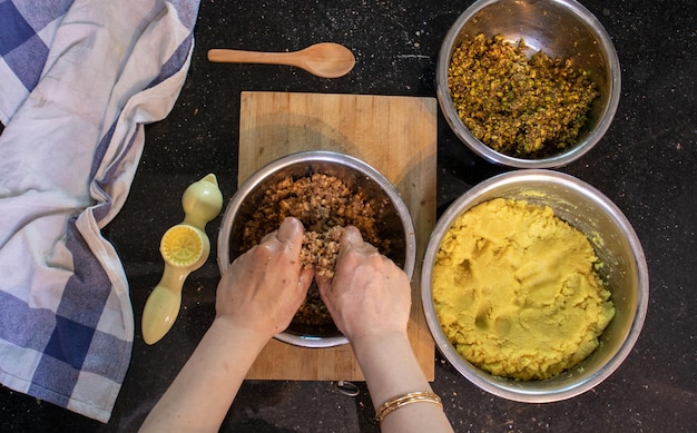 Mains de femme arabe tout en préparant des ingrédients et de la pâte d'amande pour keto kahk à la maison
