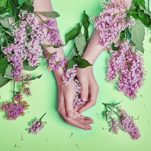 Mains de femme avec de belles fleurs lilas