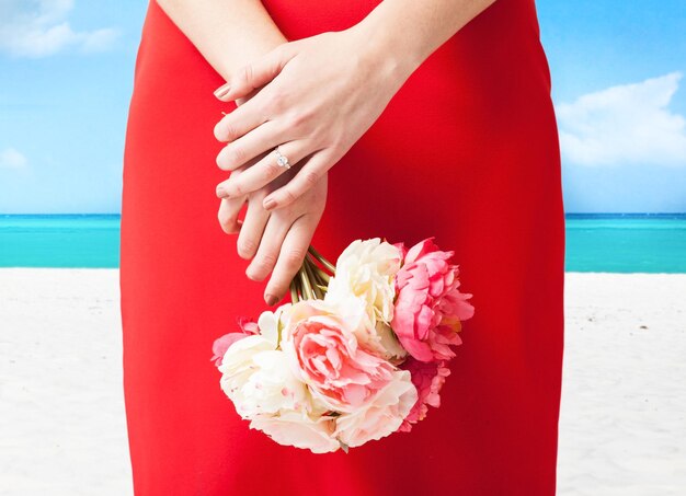 mains de femme avec bouquet de fleurs et bague de mariage