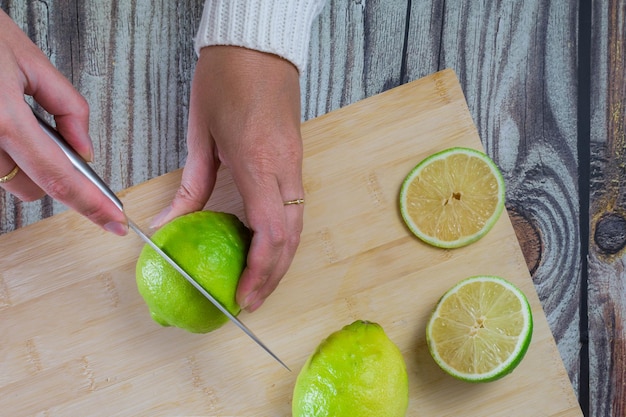 Mains de femme coupant des citrons