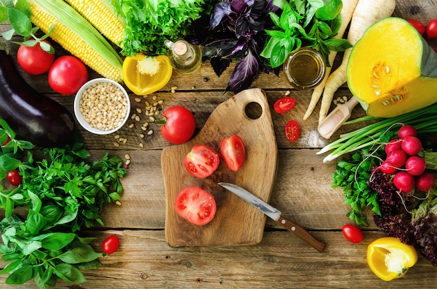 Mains de femme couper les légumes sur fond en bois. Ingrédients de cuisson des légumes