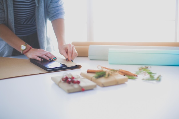 Mains de femme décorant une boîte-cadeau de noël Mains de femme