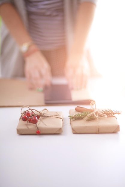 Mains de femme décorant une boîte-cadeau de noël Mains de femme