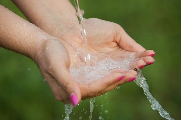 Mains de femme avec de l'eau claire qui coule