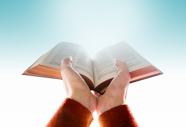 Mains de la femme élever une Bible pour prier