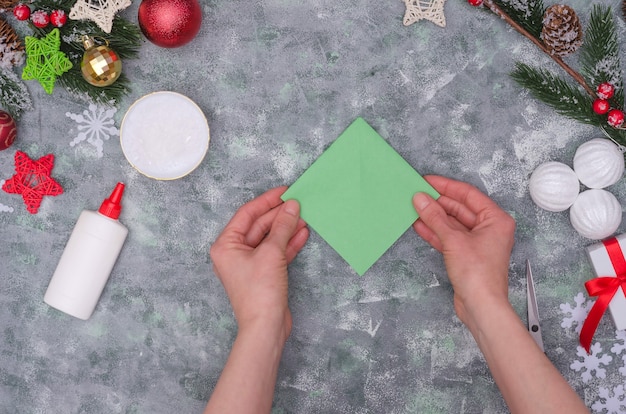 Mains de femme faisant une décoration artisanale de Noël