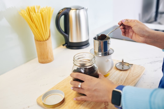 Mains de femme faisant du café de style vietnamien à la maison le matin