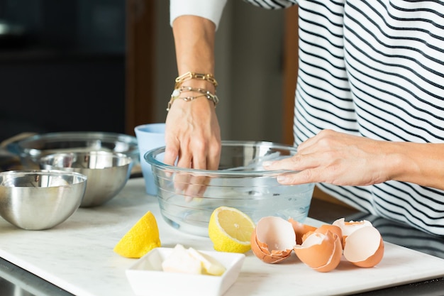 Mains de femme graissant le plat de cuisson pendant la cuisson de la tarte aux pommes