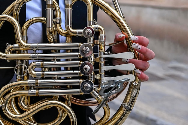 Les mains d'une femme jouant du cor ou du cor français dans l'orchestre