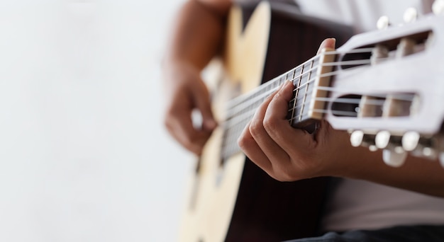 Mains de femme jouant de la guitare acoustique classique le musicien de jazz et le style d'écoute facile