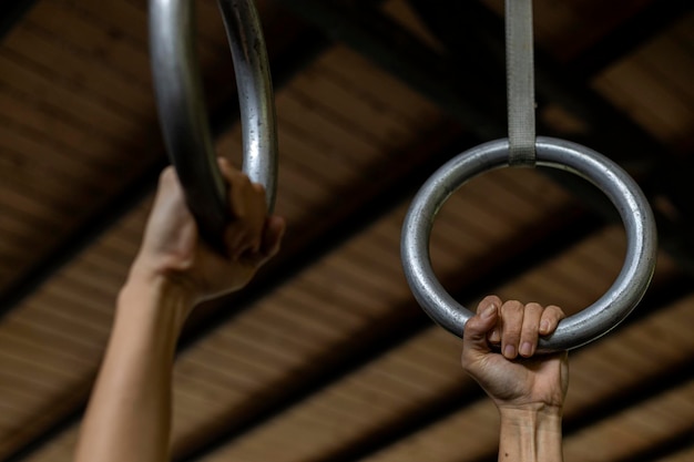 Mains de femme latino-américaine tenant des anneaux de gymnastique pendant son entraînement au gymnase Concept de mode de vie sain méconnaissable