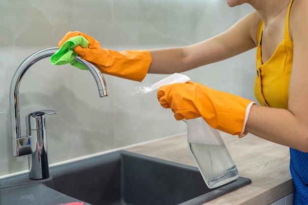 Mains de femme lavant le robinet dans la cuisine moderne