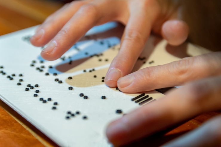 Photo mains de femme lisant le texte en braille