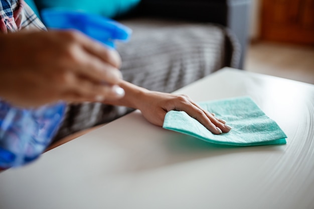 Mains de femme nettoyant les surfaces