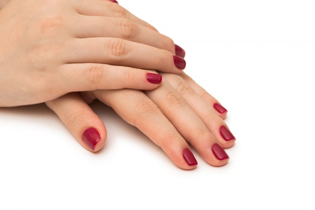 Mains de femme avec un ongle rouge isolé sur blanc