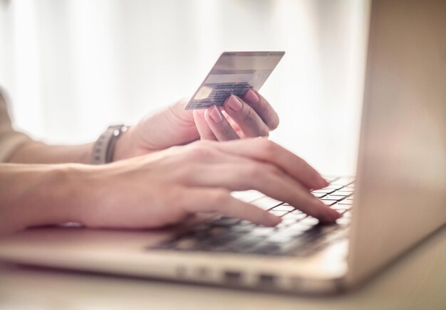 Photo les mains de la femme sur l'ordinateur portable tenant une carte de crédit