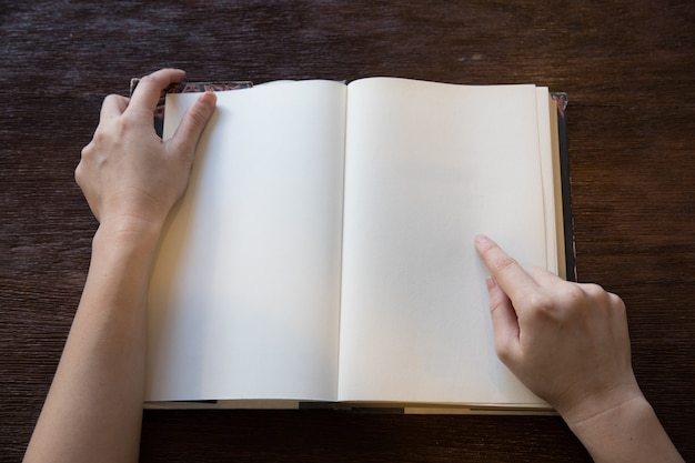 mains de femme pointent vers l&#39;espace vide du livre